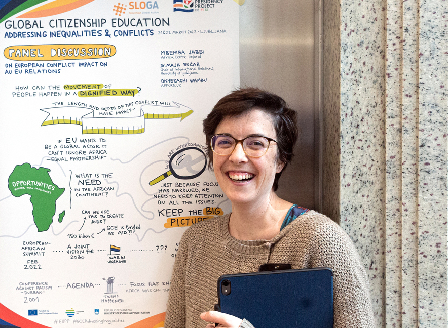 Pred plakatom, ki povzema vsebino preteklega dne risanje v živo, live illustration Slovenija, ilustratorka dogodkov